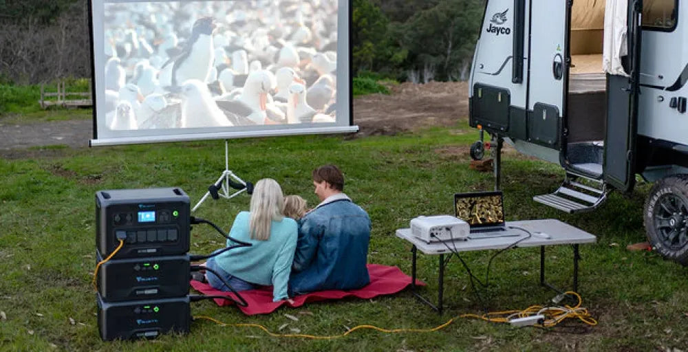 Couple enjoying an outdoor movie with Bluetti AC180P Solar Portable Power Station