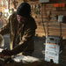 Person in beanie and jacket using Bluetti AC240P power station at a workbench